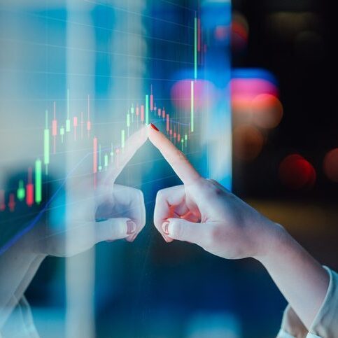Businesswomen touching stock market graph on a virtual screen display